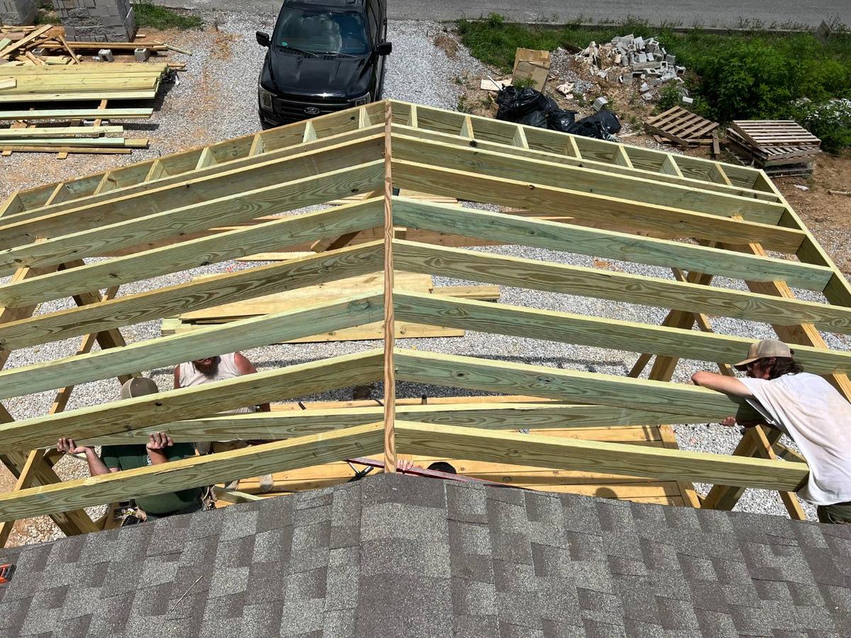 The Waterfront Solutions crew setting rafters for a gable porch roof